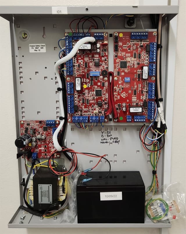 Intruder-alarm and access controller panel wired into a metal enclosure with backup battery