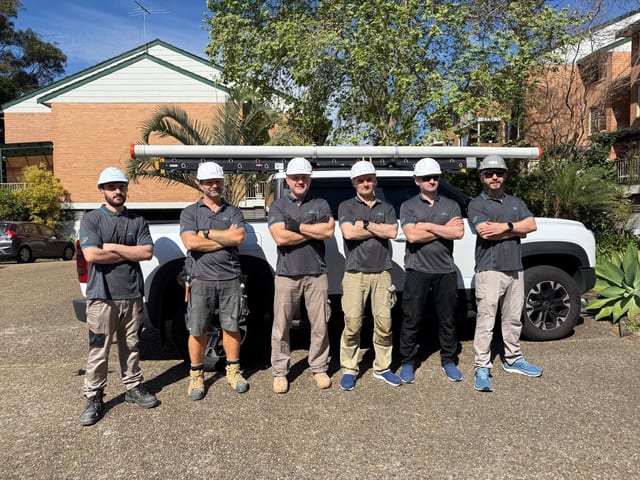 The six-person Bioni crew in branded uniforms beside the company ute on a Sydney job